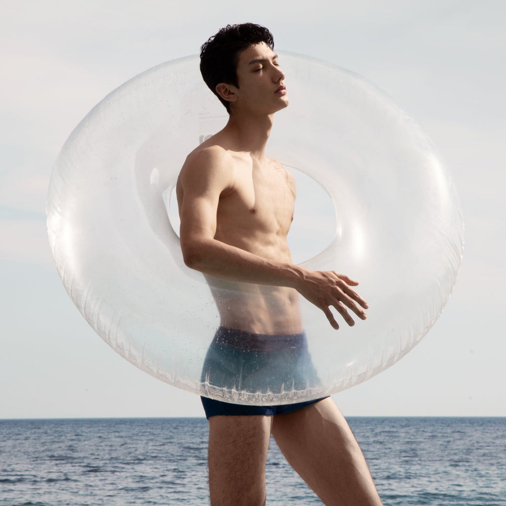 Clear Ring pool float held by young fashionable man